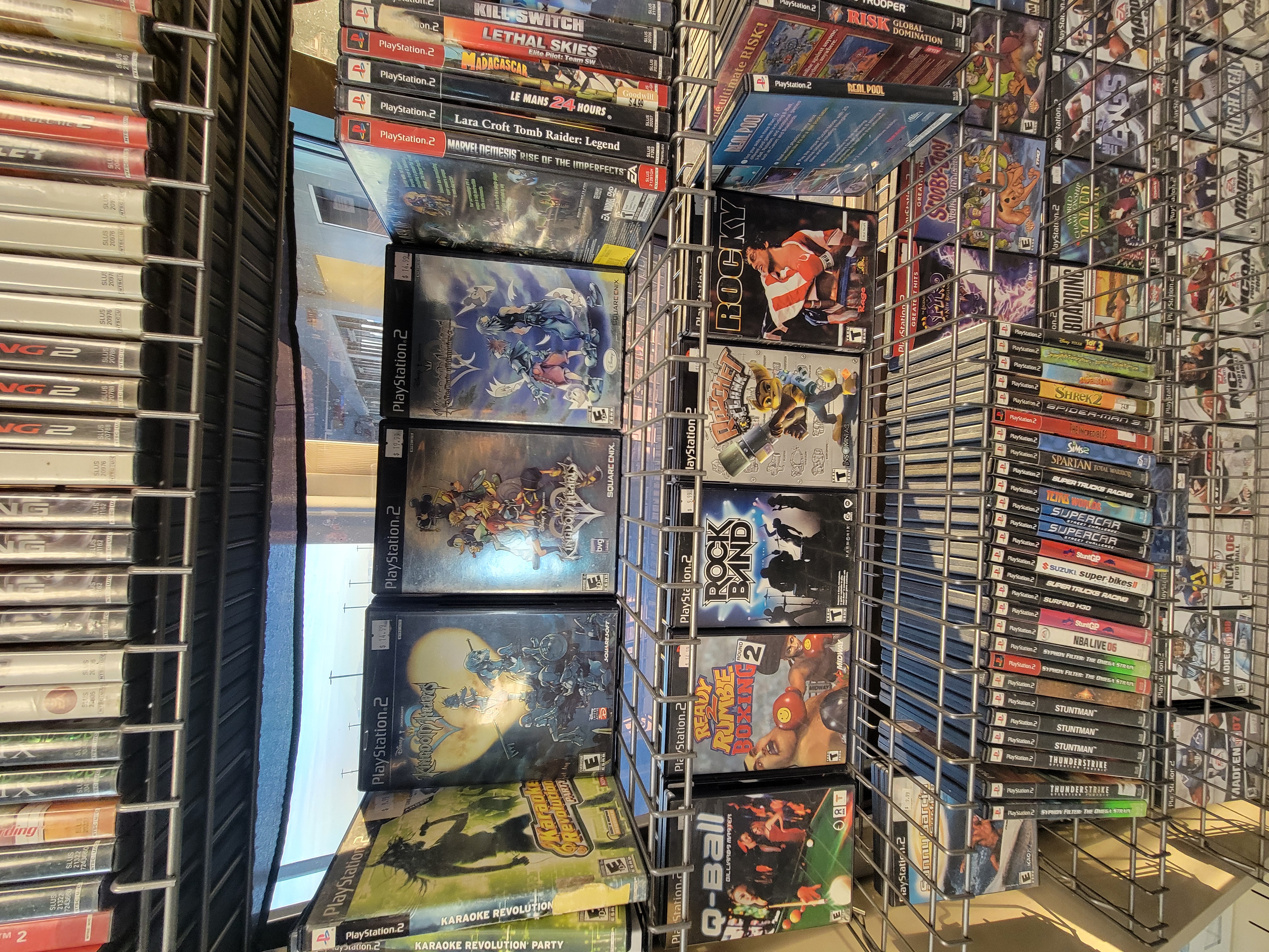 Rack of playstation 2 games with a section showing the three Kingdom Hearts games on the system.