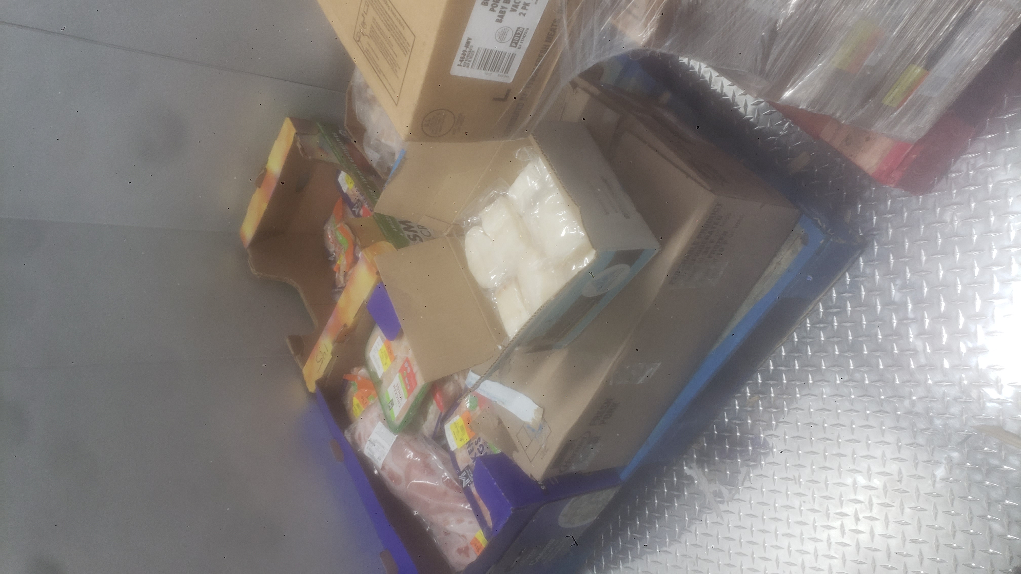 Boxes and trays of various meats on a pallet.