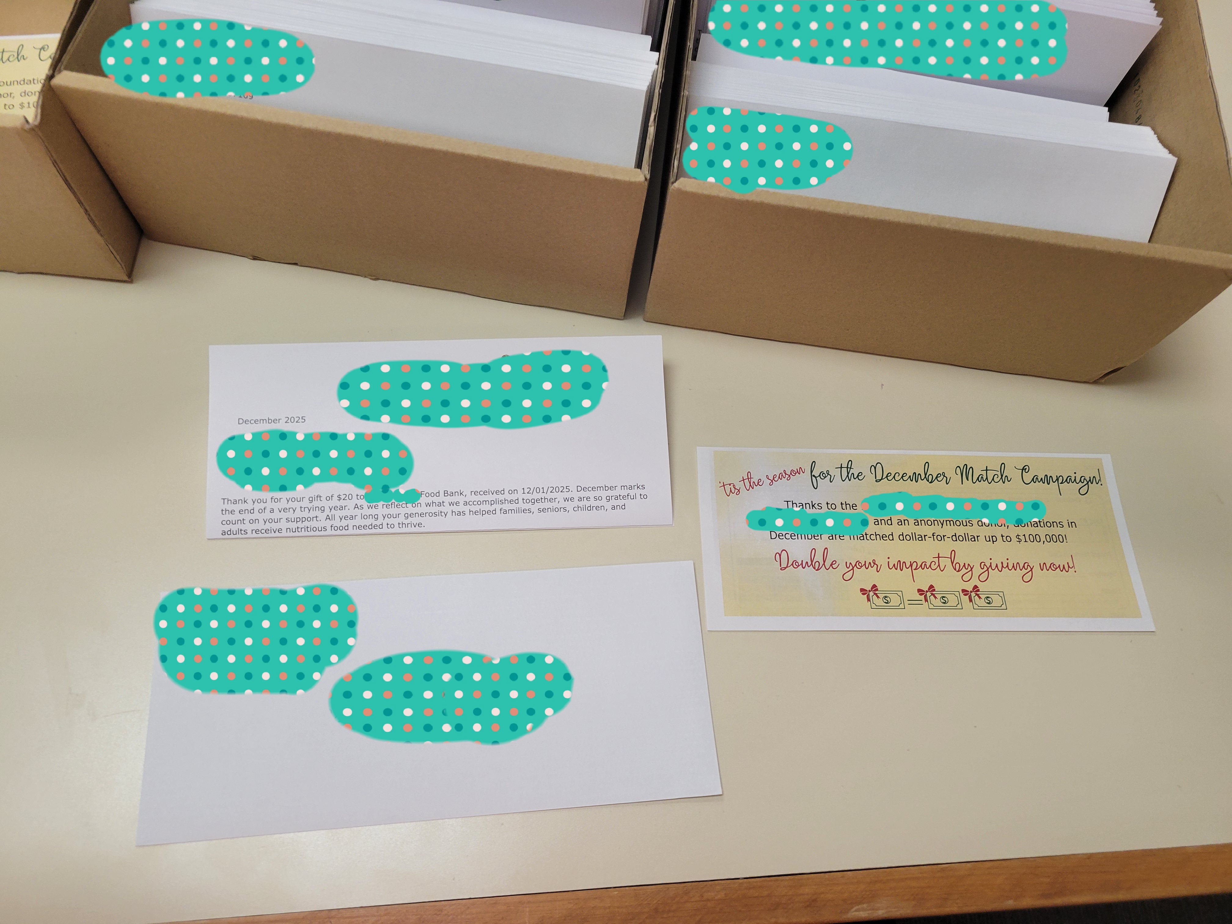 A thank you for the donation letter, a flyer outlining a donation matching champaign and envelope with boxes of letters and envelopes behind it.