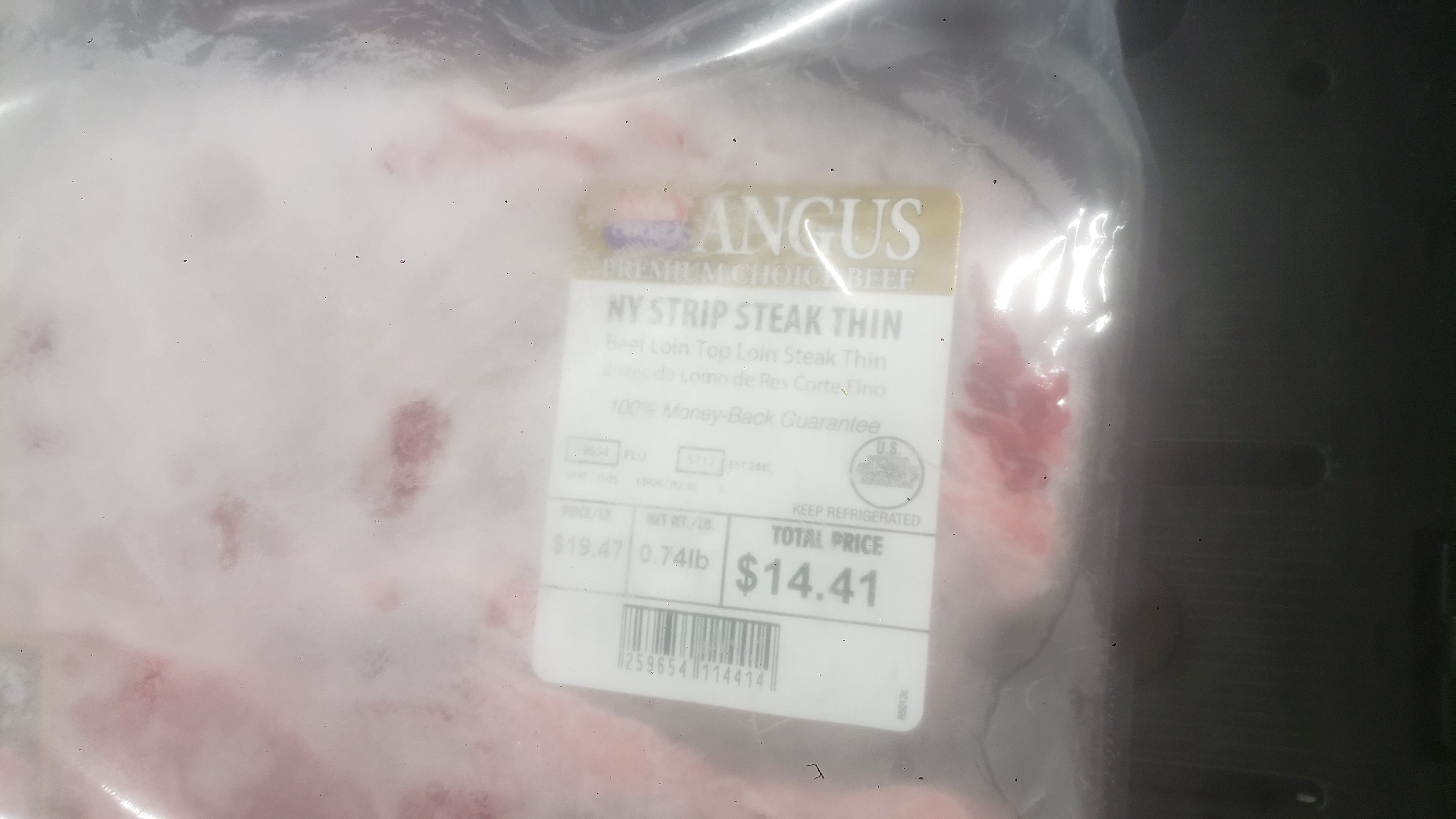 Pack of thin-cut Angus New York Strip steak covered in plastic.