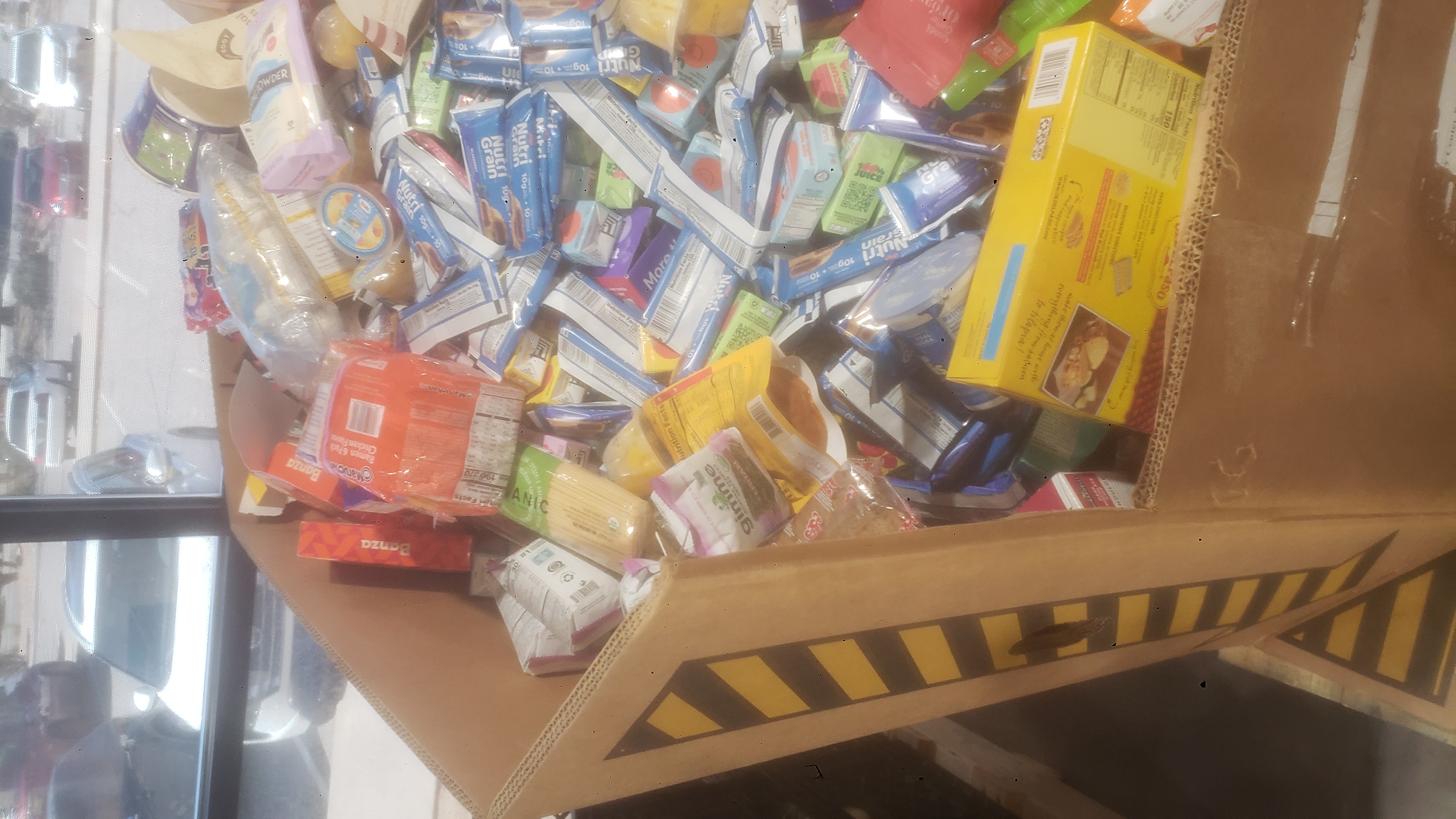 A festive Valentine's Day pallet featuring hanging red hearts with volunteers photos and silver tinsel curtains..