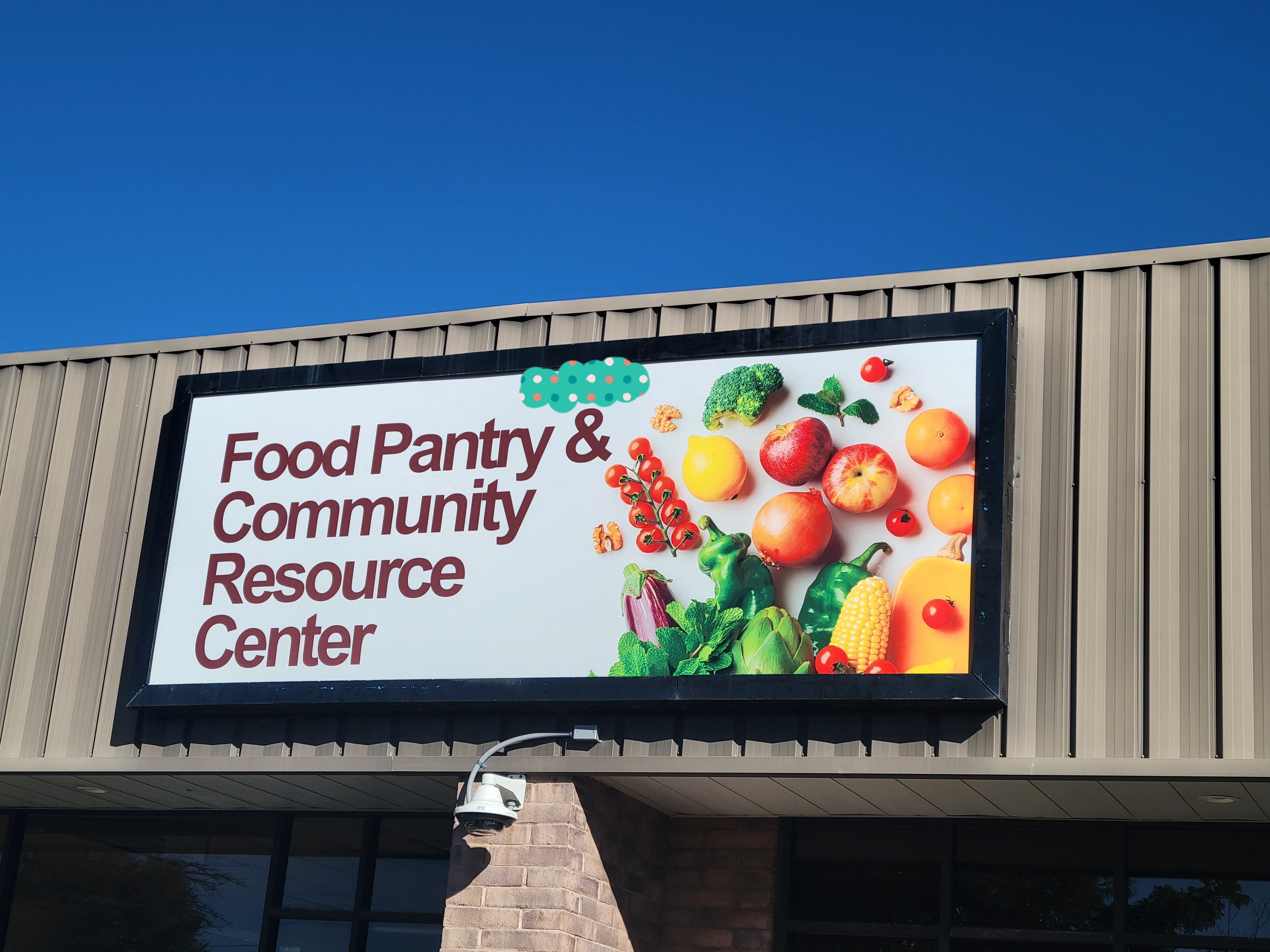 Sign that reads food pantry and community resource center with a picture of produce spilling out.