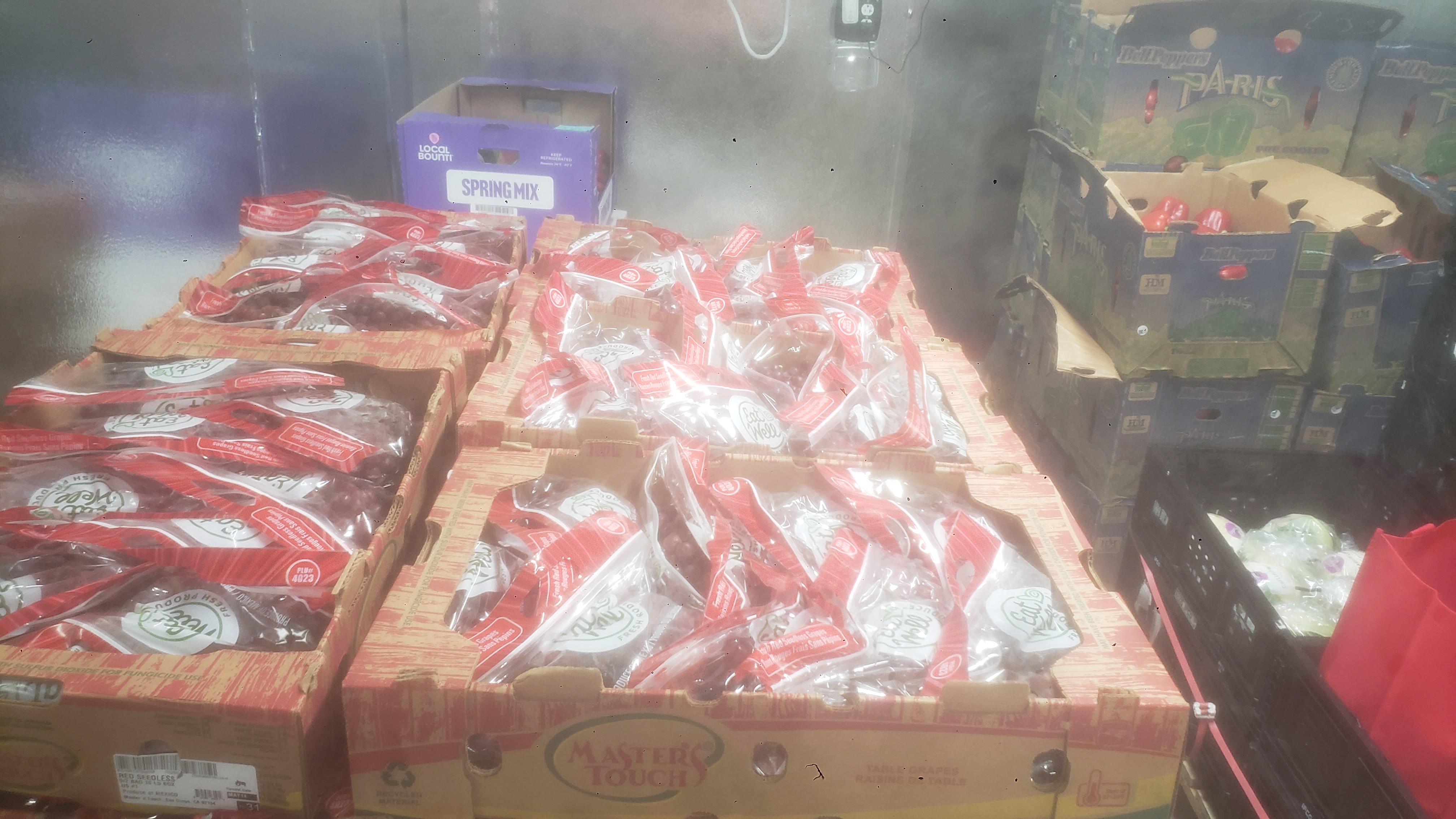 Bags of red grapes in trays.