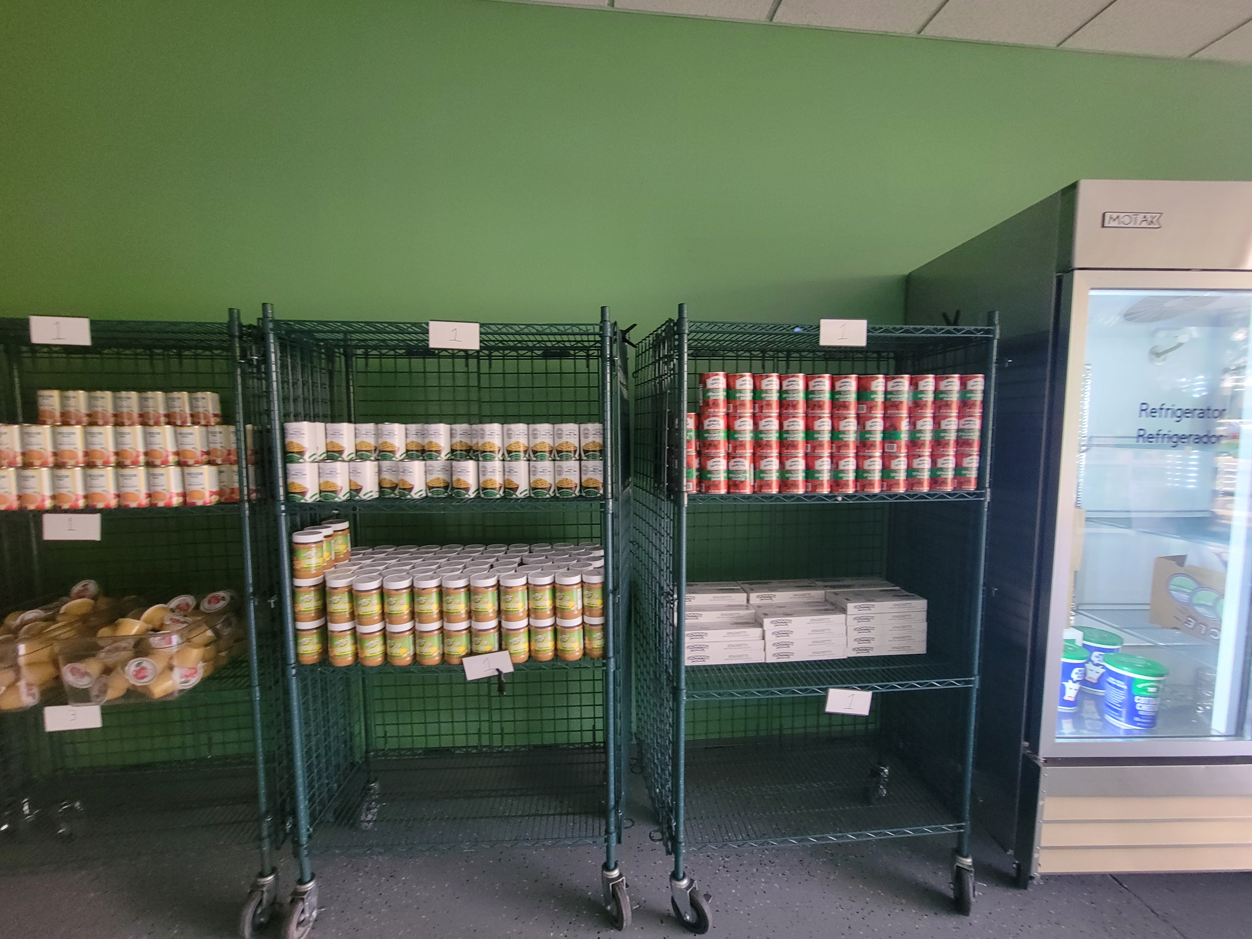 Shelves of food next to a fridge.