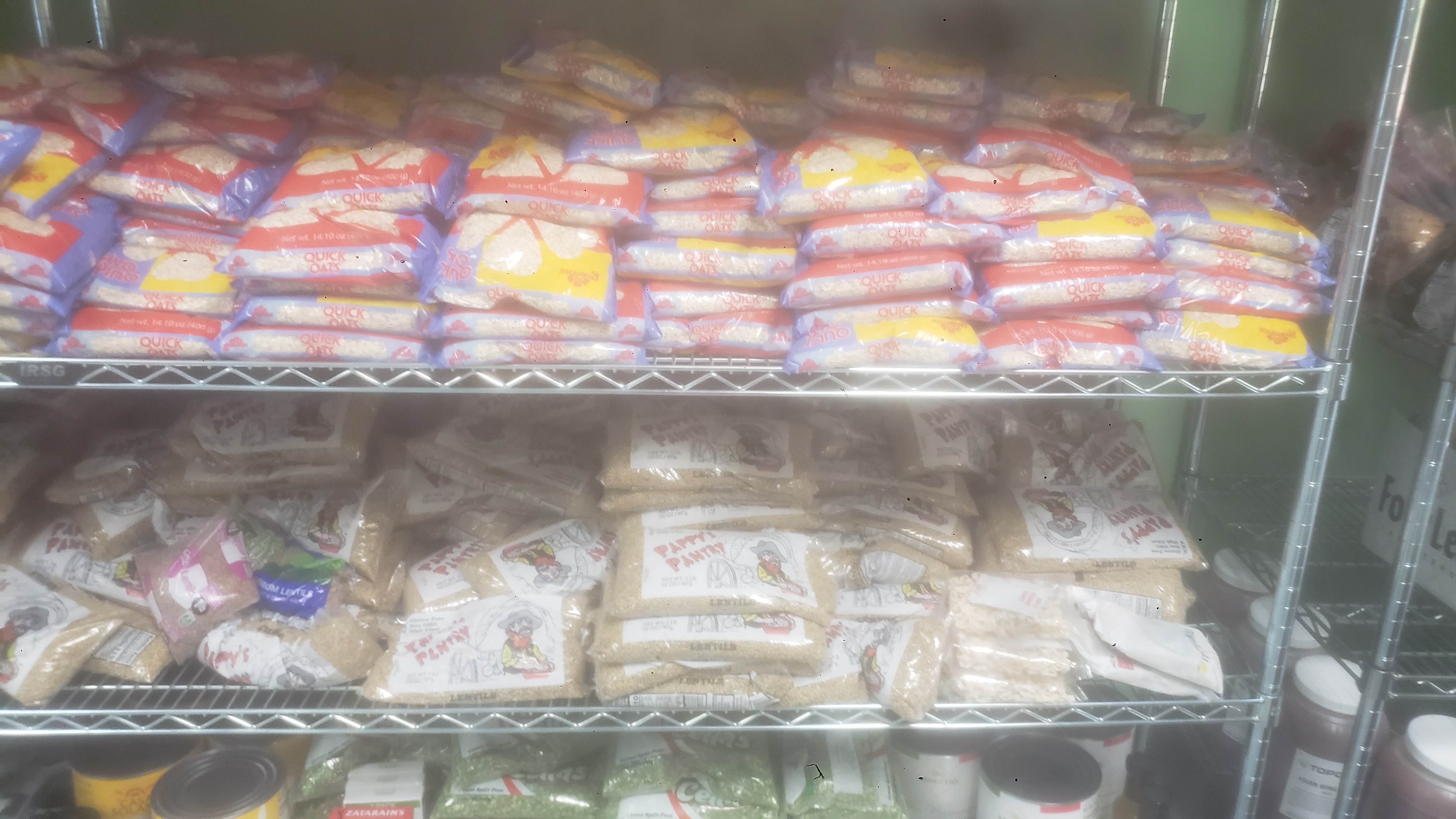 Bags of oatmeal and bags of lentils on a shelf.