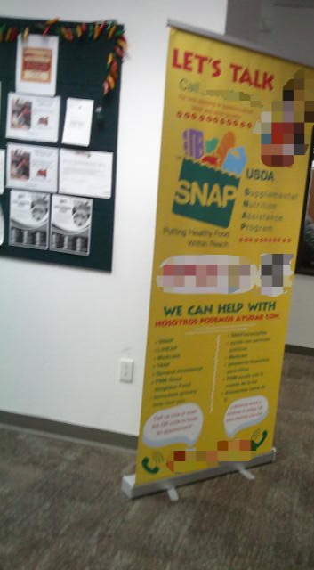 Signs talking how you can call or scan a qr code to get help with various programs such as SNAP.