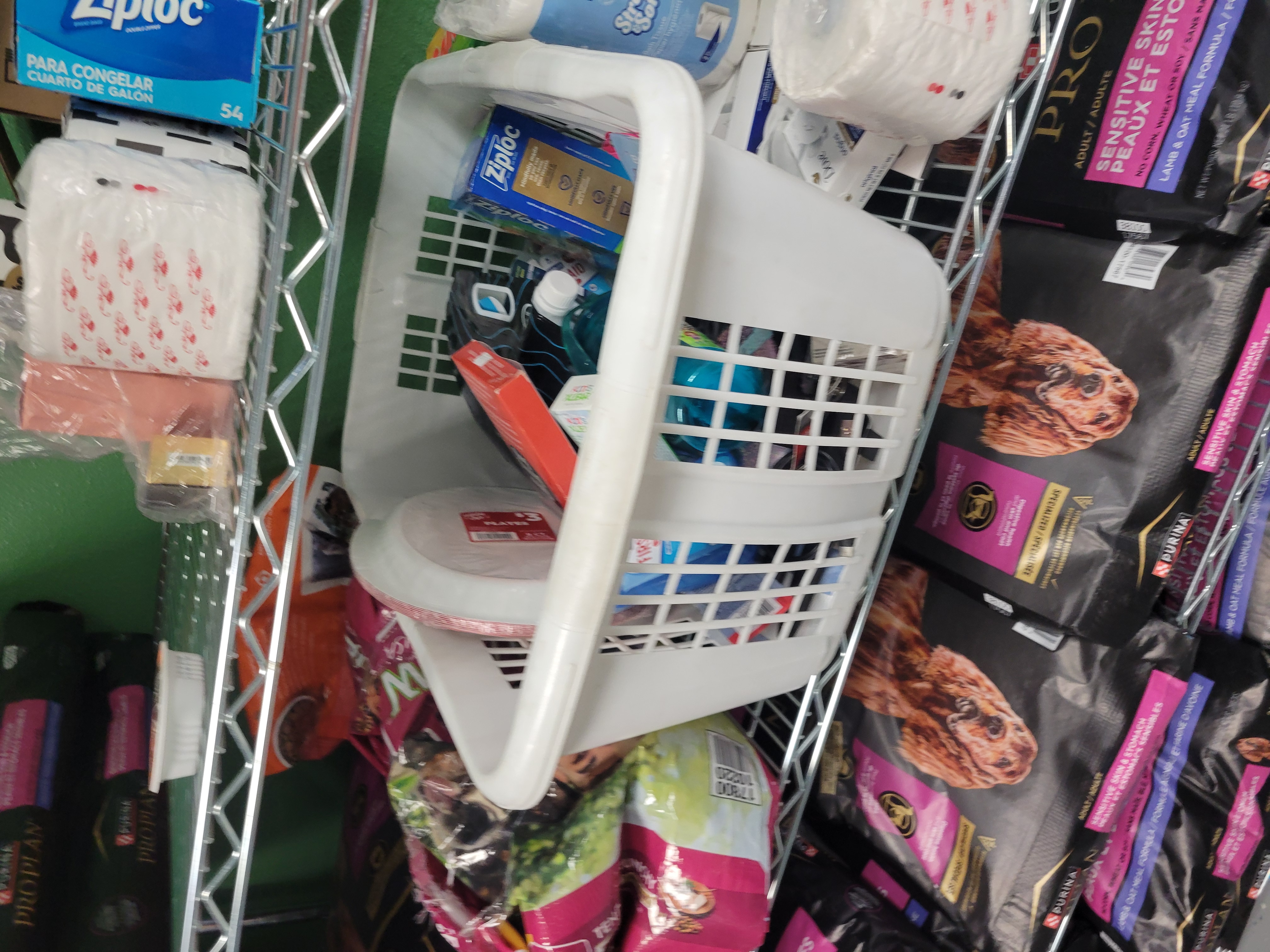 Shelf filled with big bags of dog food and household items.
