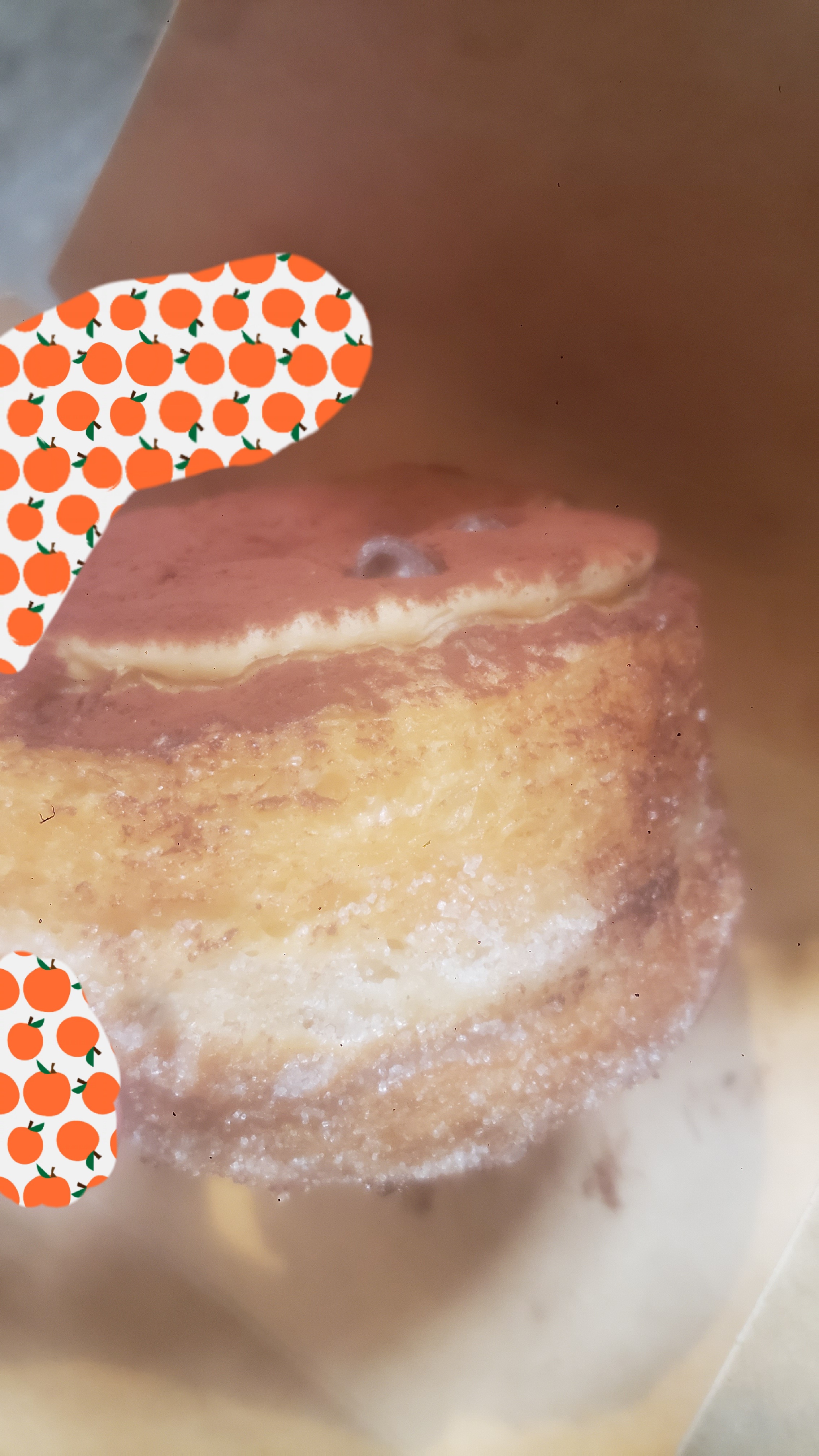Hand holds tiramisu donut in front of a to go box.
