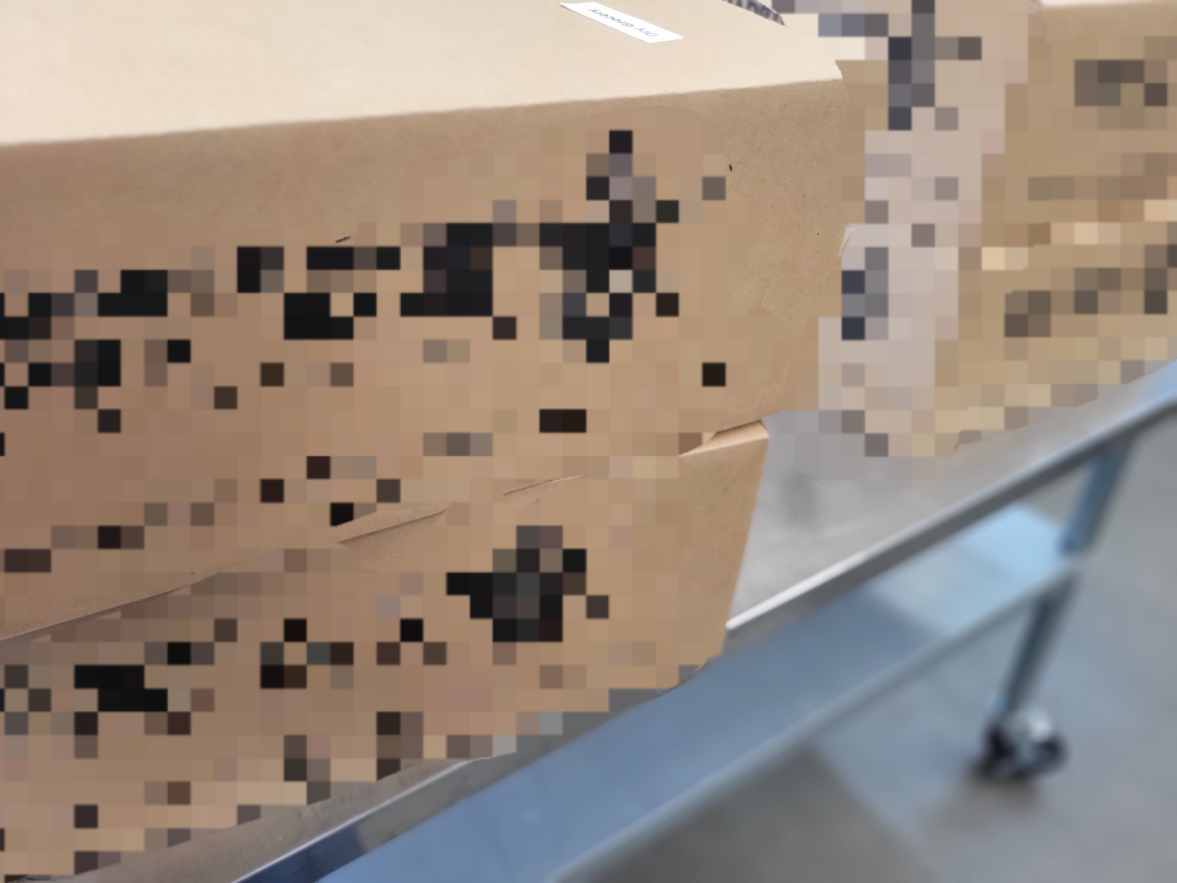 Four cardboard boxes on a metal table.