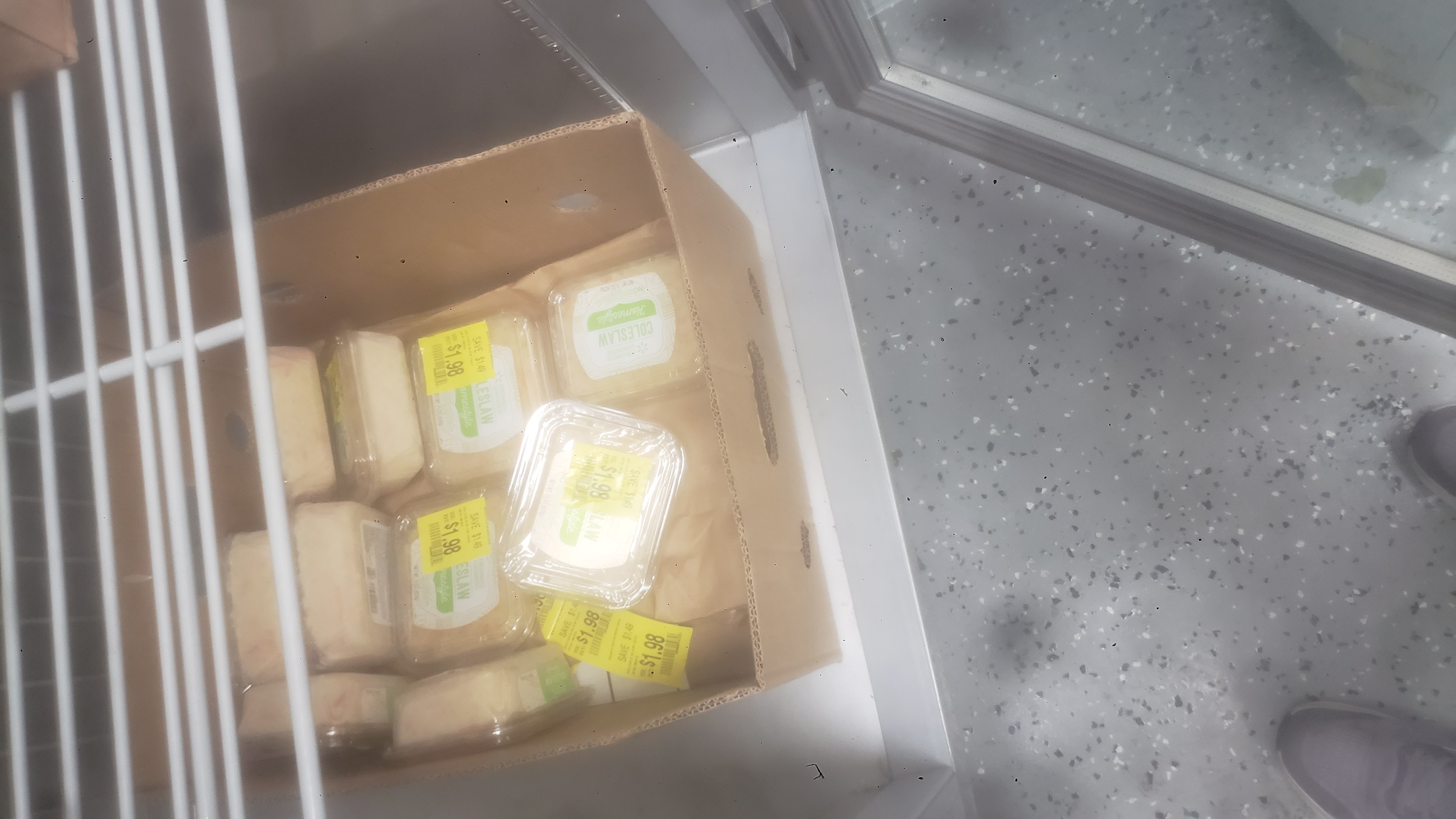 Containers of coleslaw in a banana box.