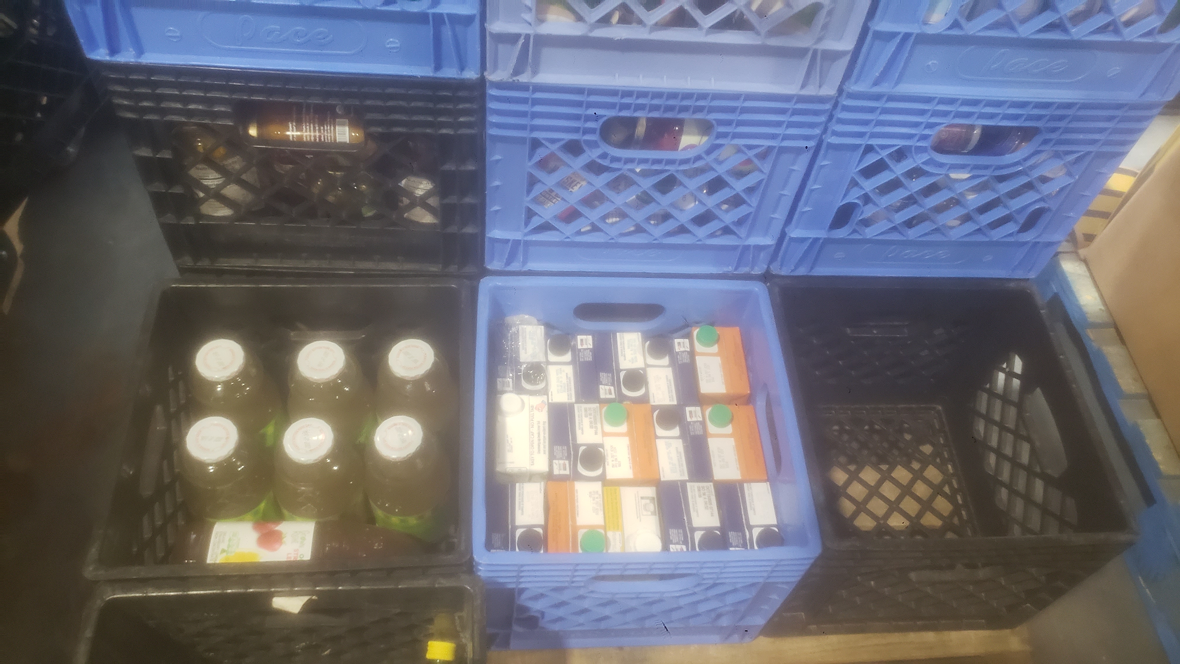 Crates full of stock cartons and bottles of juice.