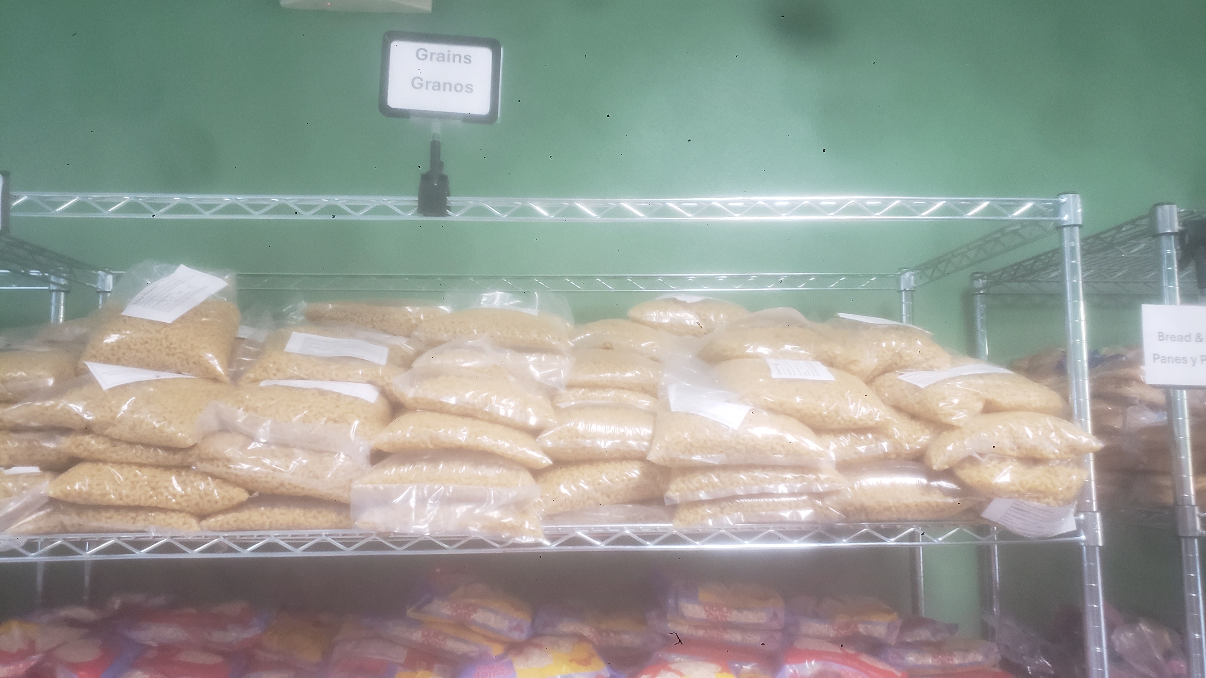Bags of macaroni and bags of oatmeals on a shelf.