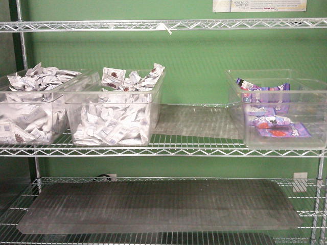 Tubs of small bags of dried cranberries and candy on second shelf.