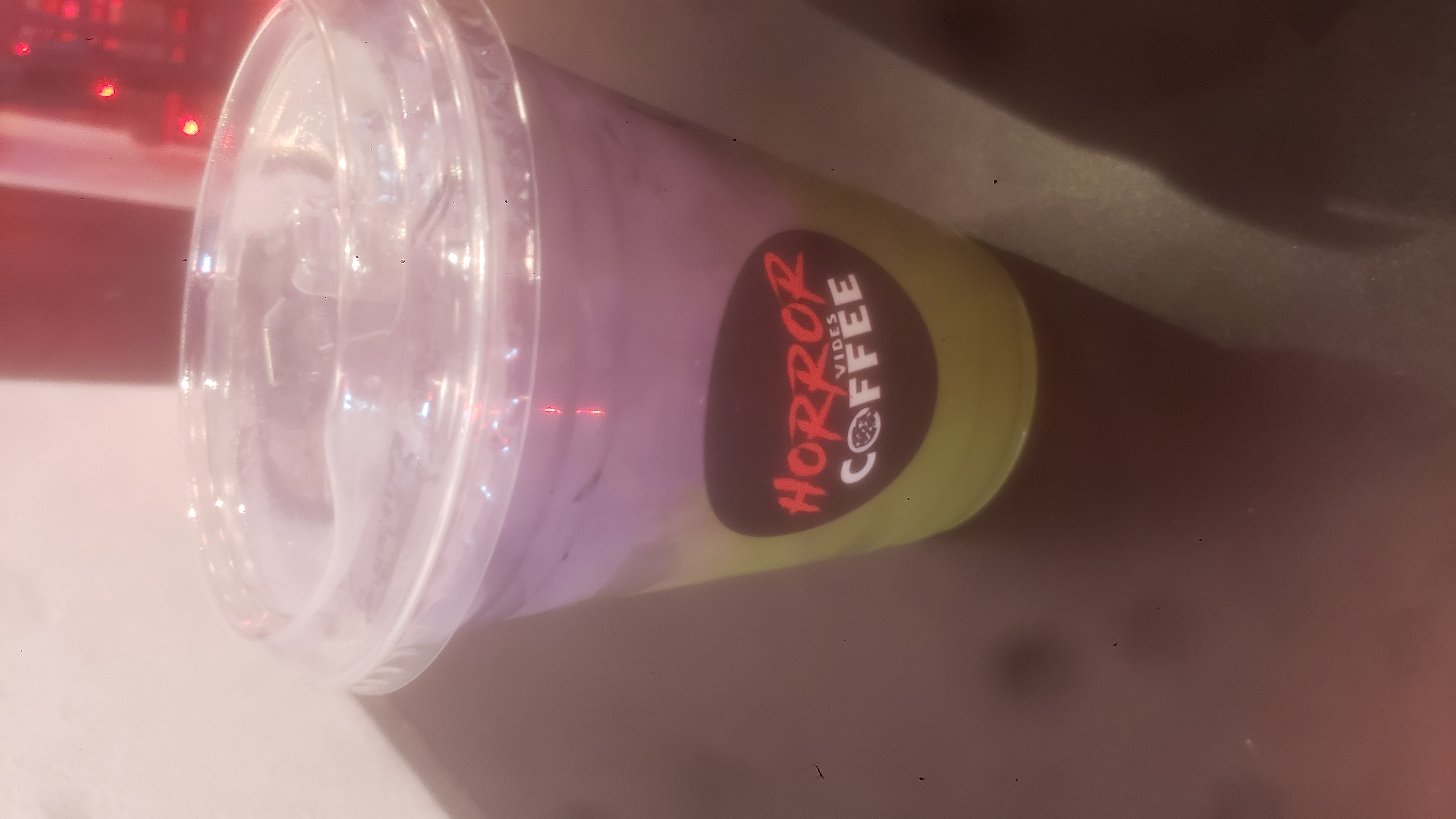 Ube matcha in a plastic to go cup with a sticker that says horror vibes coffee.