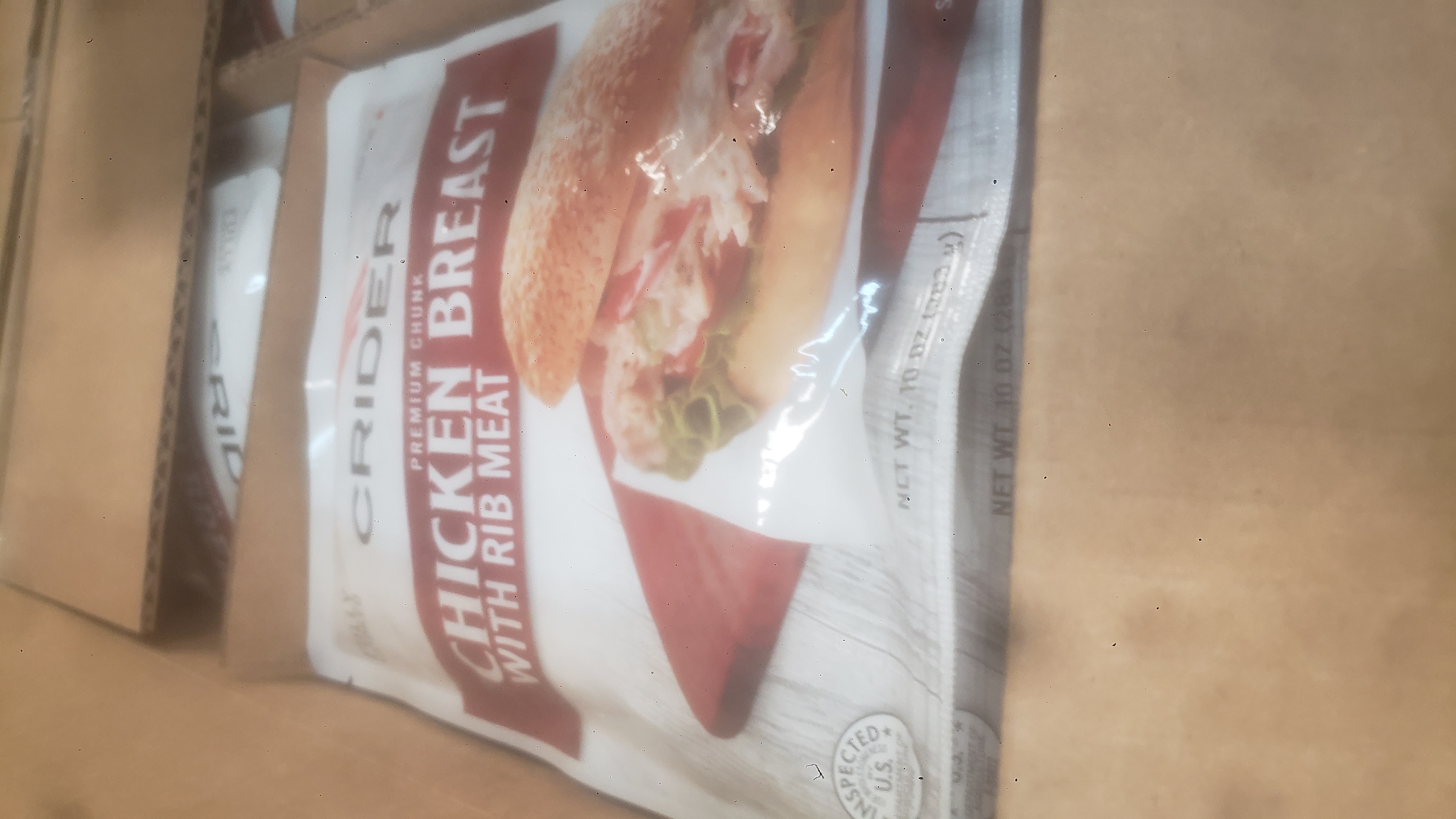 Fully cooked premium chunk chicken breast with rib meat pouches in a cardboard boxes.