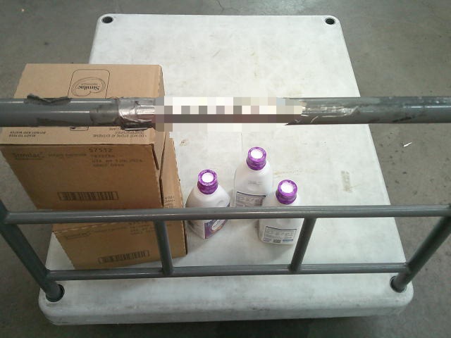 Boxes and bottles of baby formula on a push cart.