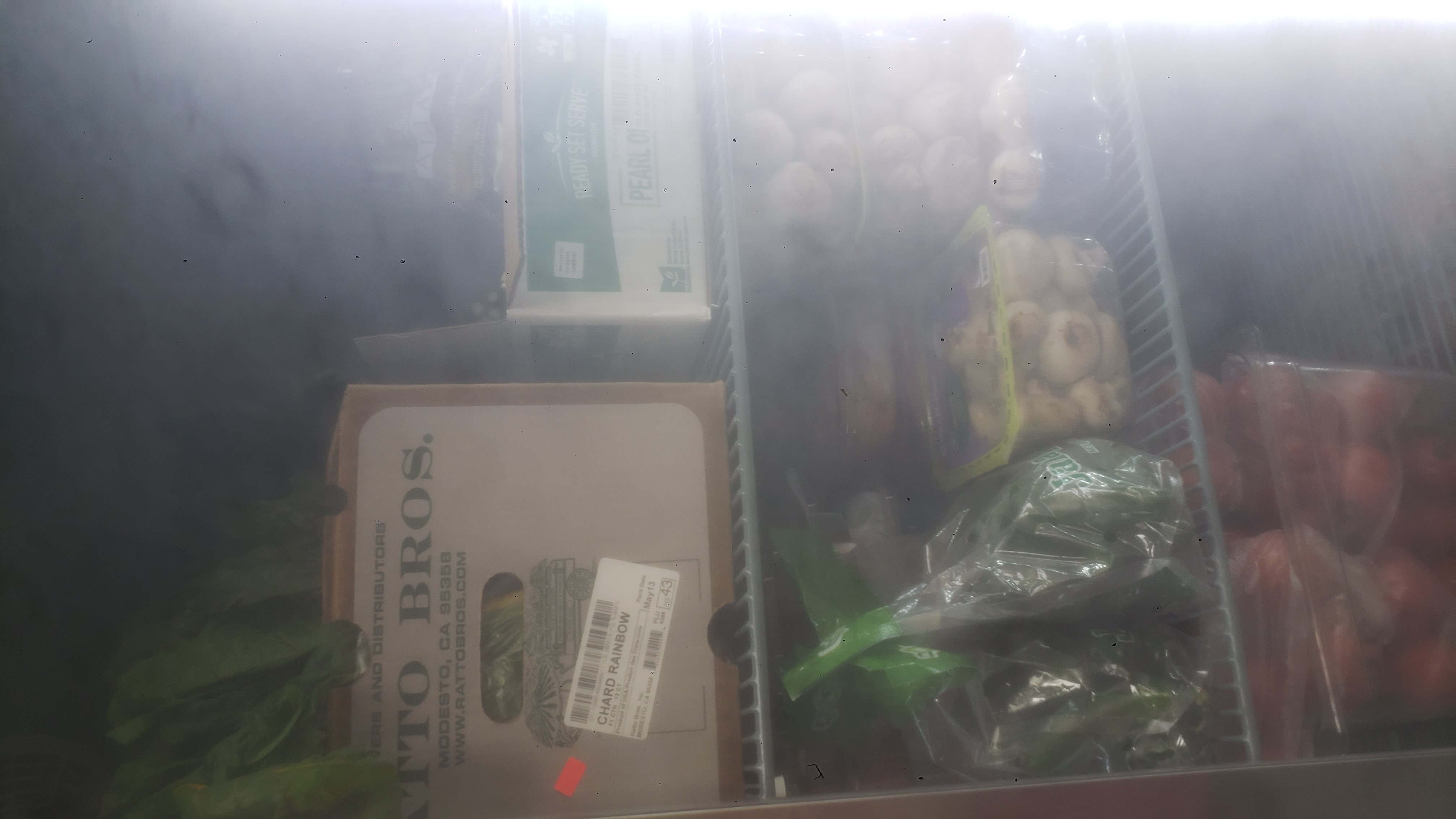 Assorted produce in a fridge.