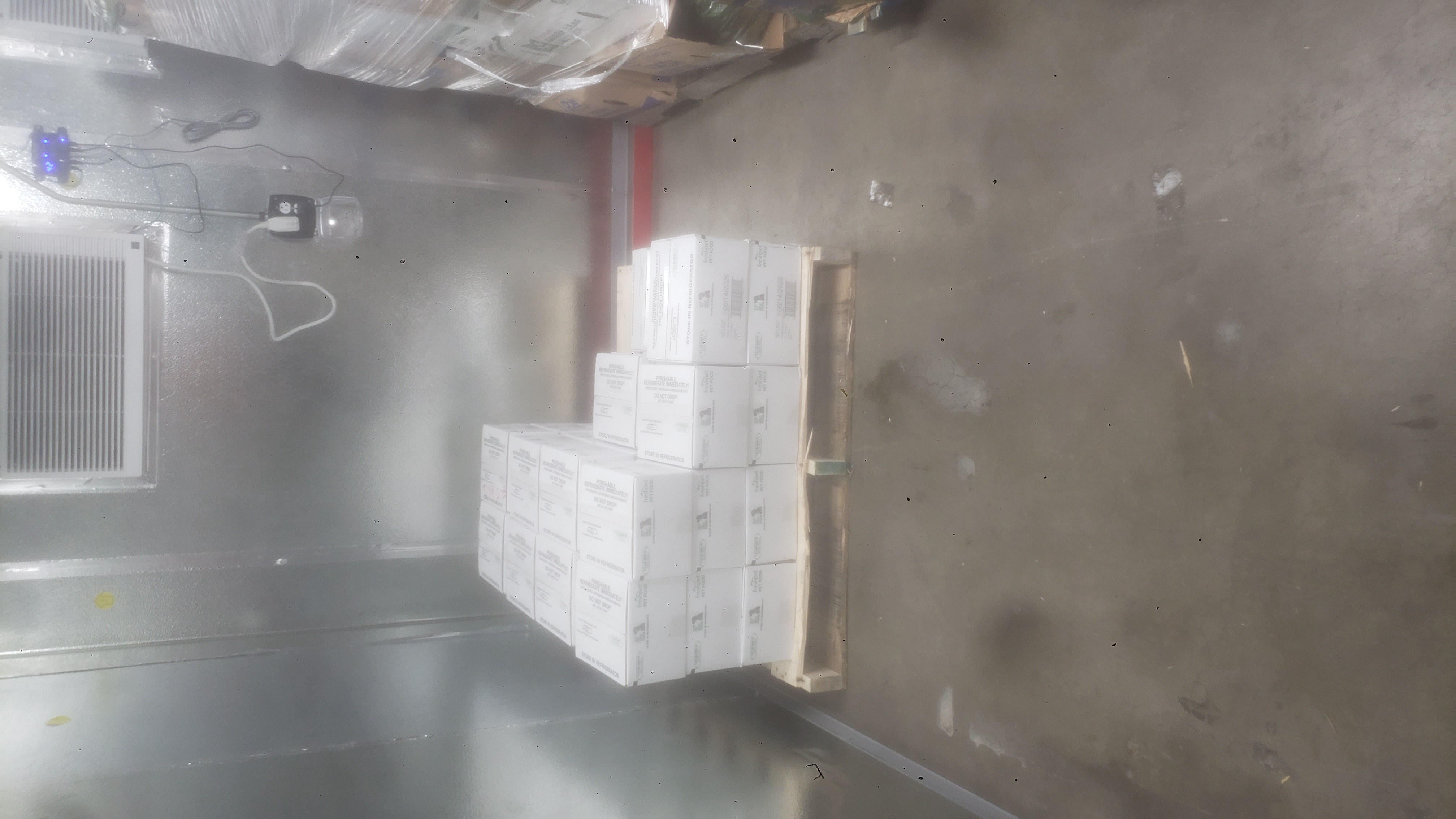 Cardboard boxes of pet food on a pallet.